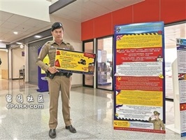 一名泰国警察举着警示牌提醒民众谨防电信诈骗